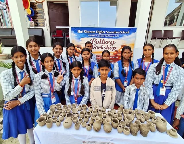 Shri Sitaram students and an educator displaying clay pots made during a pottery workshop