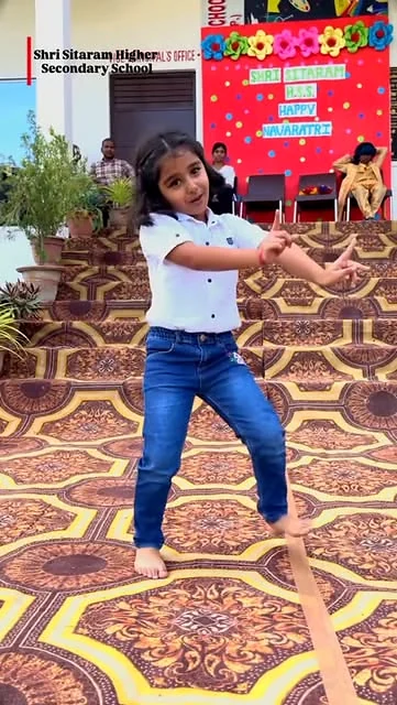 A young Shri Sitaram learner performing a colourful dance on stage